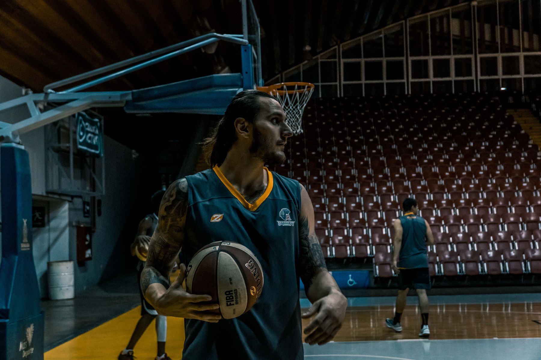 Boş basketbol salonunda antrenman yapan oyuncu